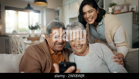 Videochiamata, soggiorno e donna con genitori anziani su un divano che si rilassa e parla al telefono. Sorridi, legame e persona femminile con anziani Foto Stock