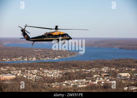 Un VH-60M Black Hawk assegnato alla Army Aviation Brigade, U.S. Army Military District of Washington, passa sopra Fort Belvoir, Virginia, durante un volo di addestramento, il 25 marzo 2024. Parte della missione della brigata include l'esecuzione del trasporto aereo prioritario per i capi dell'esercito, i funzionari del Dipartimento della difesa e i comandanti combattenti per aumentare la loro capacità di svolgere compiti ufficiali. (Foto dell'esercito degli Stati Uniti del Master Sgt. Will Reinier) Foto Stock