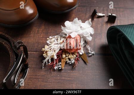 Roba per matrimoni. Composizione con elegante boutonniere su sfondo in legno Foto Stock