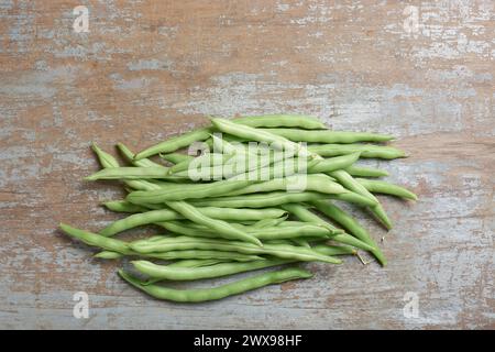 fagioli verdi su tavolo in legno, cordoncino, fagioli a pressione o bottoni, verdure per una consistenza croccante, sapore delicato e nutrizionale, vista dall'alto con spazio per copiare Foto Stock