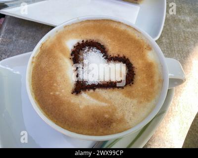 Cappuccino mit einem Kakao Herz auf verziertem Milchschaum Foto Stock