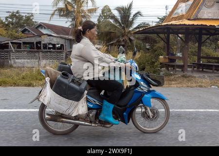 YALA, THAILANDIA, Mar 01 2024, Una donna guida una moto con un carico Foto Stock