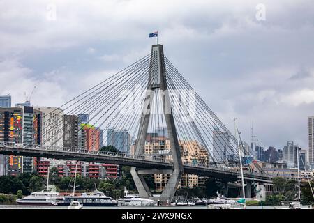 Anzac Bridge a Sydney, bandiera australiana che sventola, si estende tra Payment e Glebe e trasporta il traffico veicolare sul distributore occidentale Foto Stock