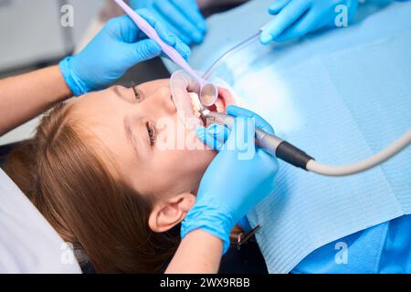 I denti delle ragazze adolescenti vengono forati in una clinica odontoiatrica Foto Stock