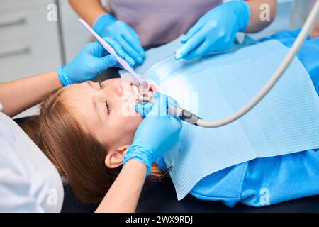 Il dente delle ragazze viene forato in una clinica odontoiatrica Foto Stock