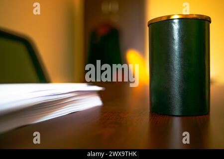 Una scatola portamatite e un mazzo di fogli A4 creano uno spazio di lavoro organizzato e funzionale per il lavoro o lo studio. Foto Stock