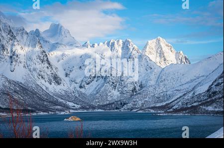 Montagne frastagliate innevate lungo un fiordo sulle isole Lofoten, Norvegia settentrionale Foto Stock