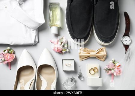 Roba per matrimoni. Composizione piatta con elegante effetto boutonniere su sfondo grigio chiaro Foto Stock