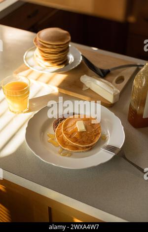 Pancake conditi con miele. Colazione con succo d'arancia e pancake Foto Stock