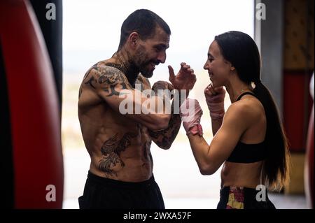 Allegra coppia che pratica il Muai Thai in palestra Foto Stock