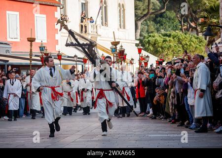 Ogni anno, nella notte tra giovedì Santo e venerdì Santo, i residenti dell'isola di Hvar, Croazia e altri pellegrini camminano per quasi 25 chilometri per seguire il crocifisso. La processione „seguendo la Croce“ è una pia tradizione che dura da oltre 500 anni. La parte più suggestiva della processione si svolge all'alba davanti alla chiesa stessa, quando il portatore della croce percorre gli ultimi 50 metri del percorso e, in climax, termina la sua lunga via Crucis in ginocchio. Il 29 marzo 2024. Foto: Zvonimir Barisin/PIXSELL Foto Stock