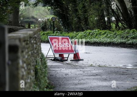 Lacock, Wiltshire, Regno Unito. 29 marzo 2024. Il fiume Avon a Lacock ha fatto scoppiare le sue sponde e ha inondato la strada dentro e fuori il villaggio. Il Consiglio è di non guidare attraverso l'acqua piena, ma la strada è percorribile se si vuole fare un tuffo. Crediti: JMF News/Alamy Live News Foto Stock