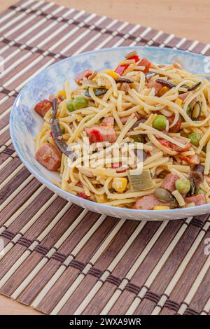 Spaghetti cinesi gialli tradizionali con verdure, carne e funghi. Messa a fuoco selettiva con profondità di campo ridotta. Foto Stock