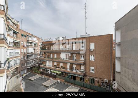 Patio interno di un blocco di case residenziali urbane con balconi e terrazze. Foto Stock