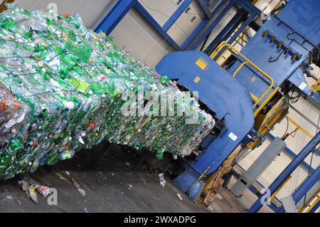 Imballatrice in un impianto di smistamento rifiuti, pressa per bottiglie di plastica macchina idraulica macchina per smistamento rifiuti, bottiglie di plastica pressate, Foto Stock