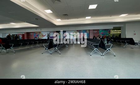 Londra, Regno Unito: 26 marzo 2024: Passeggeri in attesa di salire a bordo del volo al gate di partenza del terminal dell'aeroporto Foto Stock