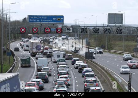 Bristol, Regno Unito. 29 marzo 2024. Le vacanze di Pasqua causano congestione del traffico sulla M5 tra gli svincoli 15/16 e 17. Sono in vigore restrizioni di velocità gestite dall'autostrada a causa del volume di traffico diretto a sud verso Devon e Cornovaglia. Le autostrade Inghilterra riportano velocità a 20 anni Crediti: JMF News/Alamy Live News Foto Stock