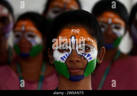 Chennai, India. 29 marzo 2024. Una ragazza indiana che mostra il potere delle elezioni in India, la più grande democrazia del mondo, dipingendo il suo volto con la bandiera indiana che chiede a tutti i cittadini di votare senza errori. Crediti: Seshadri SUKUMAR/Alamy Live News Foto Stock