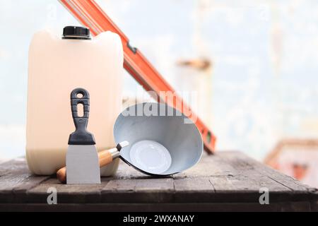 Mestolo per intonaco o da costruzione, una spatola, una livella da costruzione e un contenitore per primer. Ristrutturazione di case di campagna, costruzione. Composizione e. Foto Stock