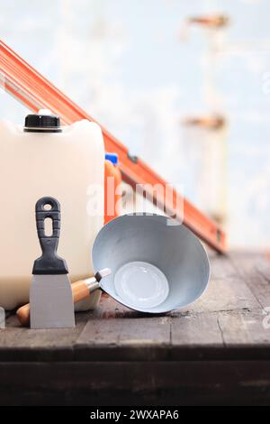 Mestolo per intonaco o da costruzione, una spatola, una livella da costruzione e un contenitore per primer. Ristrutturazione di case di campagna, costruzione. Composizione e. Foto Stock