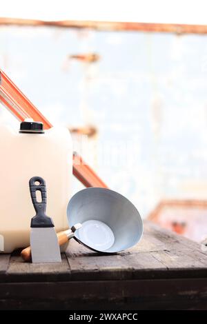 Mestolo per intonaco o da costruzione, una spatola, una livella da costruzione e un contenitore per primer. Ristrutturazione di case di campagna, costruzione. Composizione e. Foto Stock