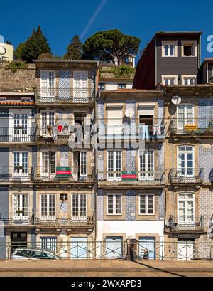 Facciate frontali di case strette nel centro storico vicino al fiume Douro a Porto, Portogallo Foto Stock