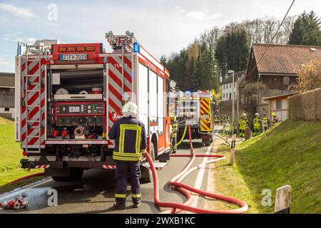 240329ID notizie del marchio: EN 2024-03-29 Unterstand komplett niedergebrannt Feuerwehr kann Übergreifen auf Wohnhäuser verhindern Kirchberg OT Stangengrün. Auf der Hirschfelder ist am Karfreitag gegen 14:30 Uhr ein Brand in einem Unterstand ausgebrochen. Zahlreiche Einsatzkräfte der Feuerwehr sind seitdem damit beschäftigt, den Brand zu löschen. Mehrere Trupps unter schwerem Atemschutz kommen hierbei zum Einsatz. VOR Ort musste eine stabile Wasserversorgung aus einem Teich in der Nähe aufgebaut werden. Dazu mussten mehrere, zirka 80 Meter lange Schlauchleitungen zum Brandort verlegt werden. MIT zwei Foto Stock