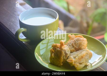 vista ravvicinata delle banane fritte e del caffè caldo. banane fritte accompagnate da caffè caldo la mattina sulla terrazza della casa. Un'abitudine fatta da Ind Foto Stock