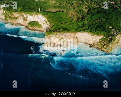 Vista aerea della costa con scogliere rocciose, oceano con onde e faro Foto Stock