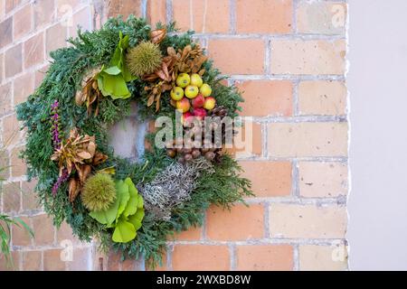 Corona di porte in materiali naturali di fronte a un muro di casa, Renania-Palatinato, Germania Foto Stock