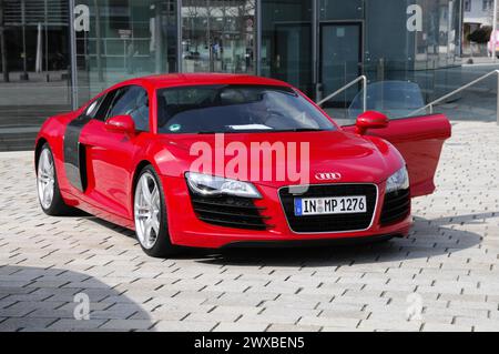 Un'auto sportiva rossa Audi R8 parcheggiata di fronte a un edificio moderno, Museum mobile, Audi Museum, Audi, Ingolstadt, Baviera, Germania Foto Stock