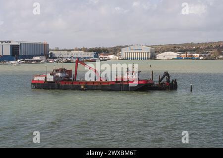 Dredger e retroescavatore, scavando nel porto di Portsmouth. Foto Stock