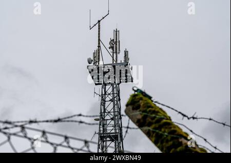 Mobillfunksender auf Sendemast des ehemaligen Warnamtes Meinerzhagen IM Zuge der Auflösung im Jahre 1997 wurde auch das Warnamt Meinerzhagen Märkischer Kreis, Sauerland stillgelegt. Auf dem Anwesen sind mittlerweile Privatfirmen angesiedelt. Der Sendemast wird weiter artgerecht genutzt und beherbergt Richtfunkstrecken und Mobilfunkantennen. DAS Gelände ist noch immer gut gesichert: Aufgrund der Funktion der Warnämter während des Kalten Krieges ist die Liegenschaft ähnlich wie eine Kaserne oder eine Grenzanlage gesichert: MIT Stacheldraht und hohen Zäunen. für Unbefugte ist das Grundstück noch Foto Stock