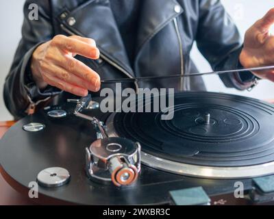 Una signora inriconoscibile che detiene un disco in vinile pronto a riprodurlo sul suo giradischi Foto Stock