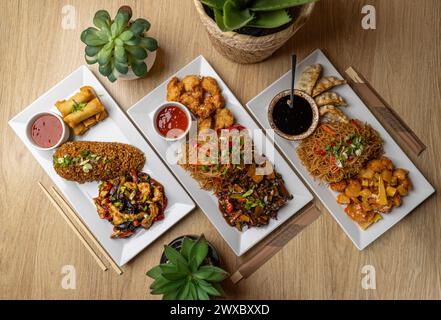 Prelibatezze di cucina asiatica assortite su un tavolo di legno. Cucina asiatica Foto Stock