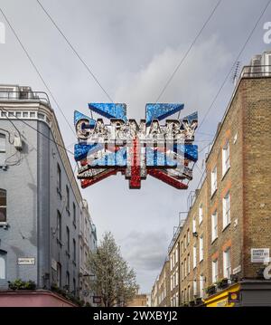 La scintillante bandiera Union sopra Carnaby Street è un simbolo della cultura e della moda britannica, con i suoi dischi a specchio che riflettono l'atmosfera vibrante della zona. Foto Stock