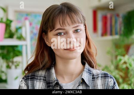 Ritratto di una ragazza sorridente che guarda la fotocamera a casa Foto Stock