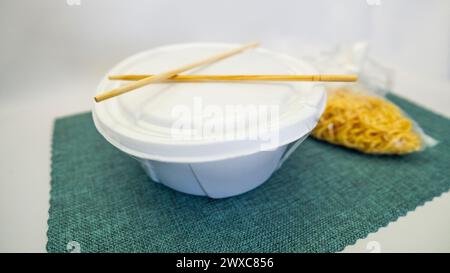 Yakisoba nel cestino da pranzo e nel piatto con Chique Hashi Foto Stock