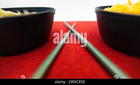 Yakisoba nel cestino da pranzo e nel piatto con Chique Hashi Foto Stock