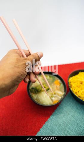 Yakisoba nel cestino da pranzo e nel piatto con Chique Hashi Foto Stock