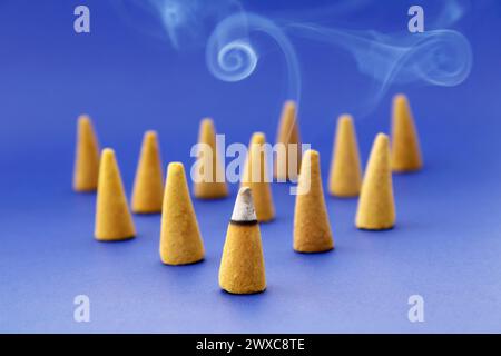 Incenso a forma di cono con uno di loro che brucia davanti Foto Stock