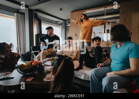 Gruppo di giovani amici che si godono un incontro informale con la musica della chitarra. Foto Stock