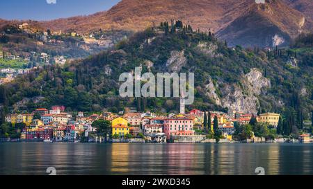 Centro storico di Varena sul Lago di Como, Italia con montagne sullo sfondo Foto Stock