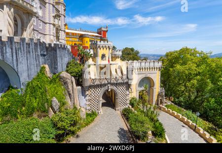Esterno panoramico aereo e ampia vista del colorato Palácio da pena con il sentiero che porta all'ingresso ad arco decorato con bassorilievi, sotto un sole Foto Stock