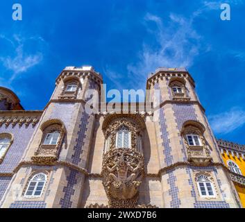 Vista frontale ad angolo basso dell'ingresso al cortile ad arco del Palazzo da pena con la statua di Tritone su un guscio con intaglio decorativo in pietra abo Foto Stock