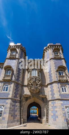 Ingresso al cortile ad arco di Palazzo pena dalla facciata con mosaici blu e la statua di Tritone con sculture decorative in pietra sopra il Foto Stock