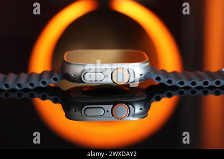 Un'immagine nera e arancione davvero sorprendente e un Apple Watch Ultra con Ocean Band grigio Foto Stock