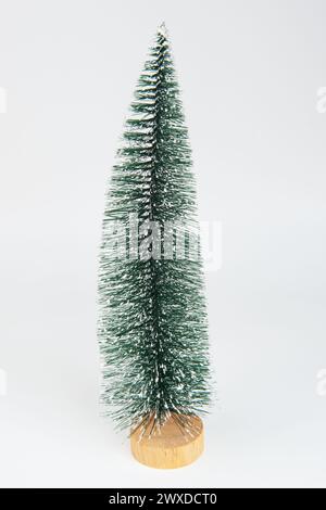 L'albero di pino invernale in miniatura con neve è decorato per creare un'atmosfera natalizia. Foto Stock