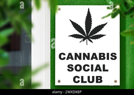 30 marzo 2024: Cannabis Social Club, insegna con foglie di canapa su un muro di fronte a un ingresso. FOTOMONTAGGIO *** Cannabis Social Club, Schild mit Hanfblatt auf einer Wand vor einem Eingang. FOTOMONTAGE Foto Stock