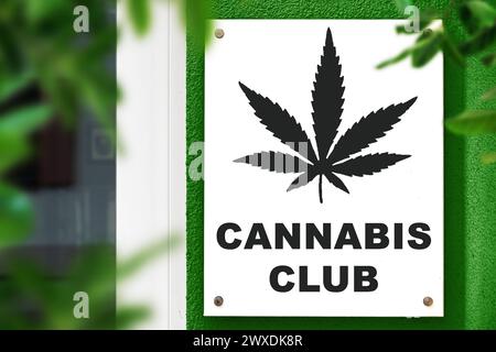 30 marzo 2024: Cannabis Club, insegna con foglie di canapa su un muro di fronte a un ingresso. FOTOMONTAGGIO *** Cannabis Club, Schild mit Hanfblatt auf einer Wand vor einem Eingang. FOTOMONTAGE Foto Stock